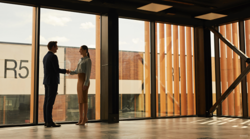 a man and a woman shaking hands in an empty office