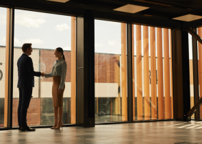 homme et femme qui se serrent la main, dans un environnement de bureau en location